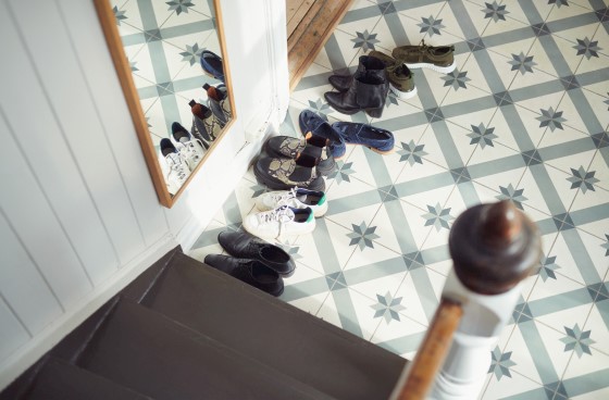 Flere skopar står på gulvet i en gang i et bolighus eller en leilighet. Foto.